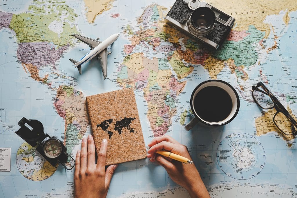 woman planning her vacation using world map by Vacancy Rewards