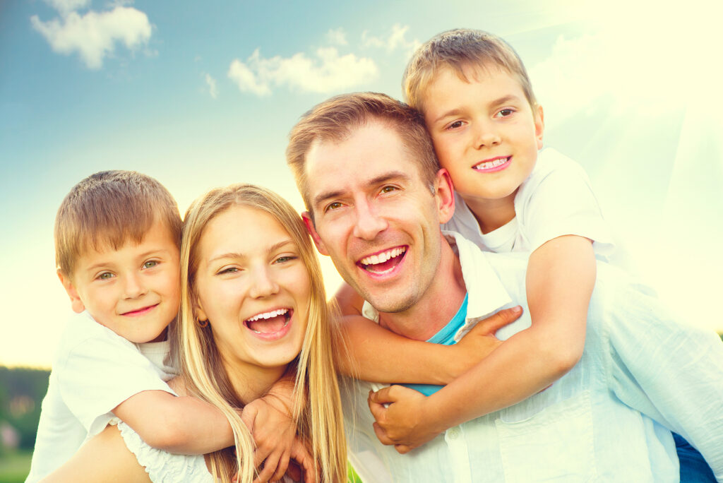 Happy joyful young family father, mother and kids having fun out